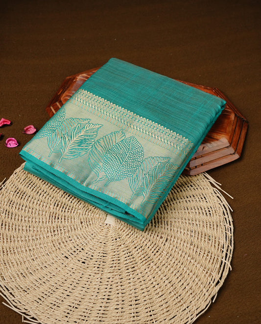 Aqua colour semi tussar silk saree featuring an elegant plain body with traditional gold zari detailed border for a refined look. Comes paired with a matching blouse piece.