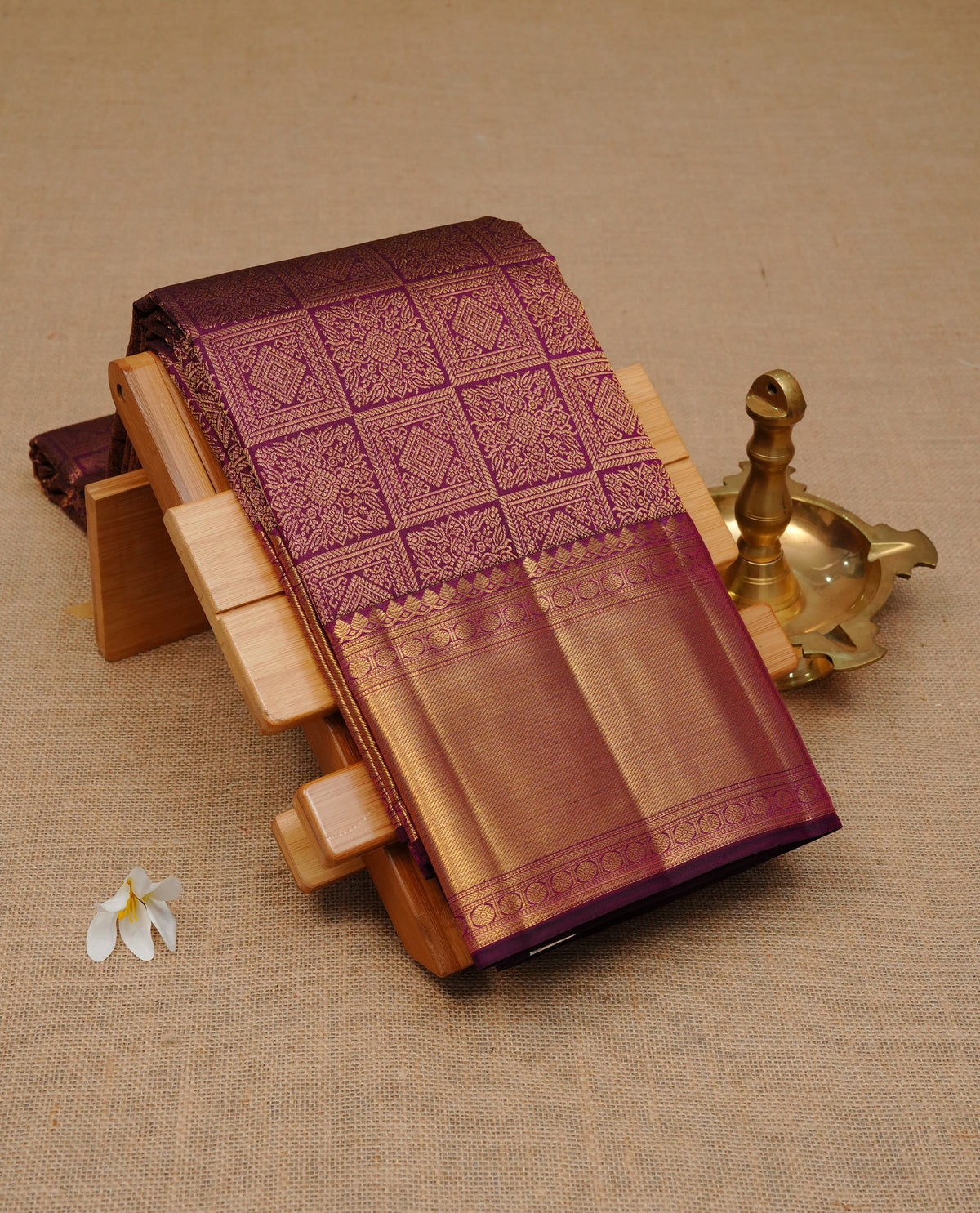 Deep purple colour pure wedding silk saree featuring gold zari designed box pattern on body, complemented by self colour with traditional border, comes with matching blouse piece.