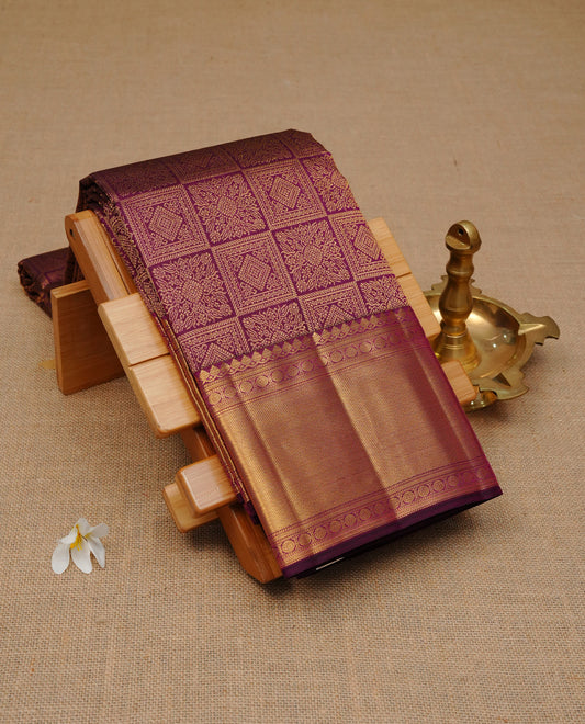 Deep purple colour pure wedding silk saree featuring gold zari designed box pattern on body, complemented by self colour with traditional border, comes with matching blouse piece.