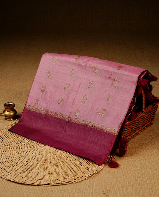 Pink colour banaras silk saree featuring Gold zari buttas on body, complemented by contrast Maroon colour border, comes with matching blouse piece.