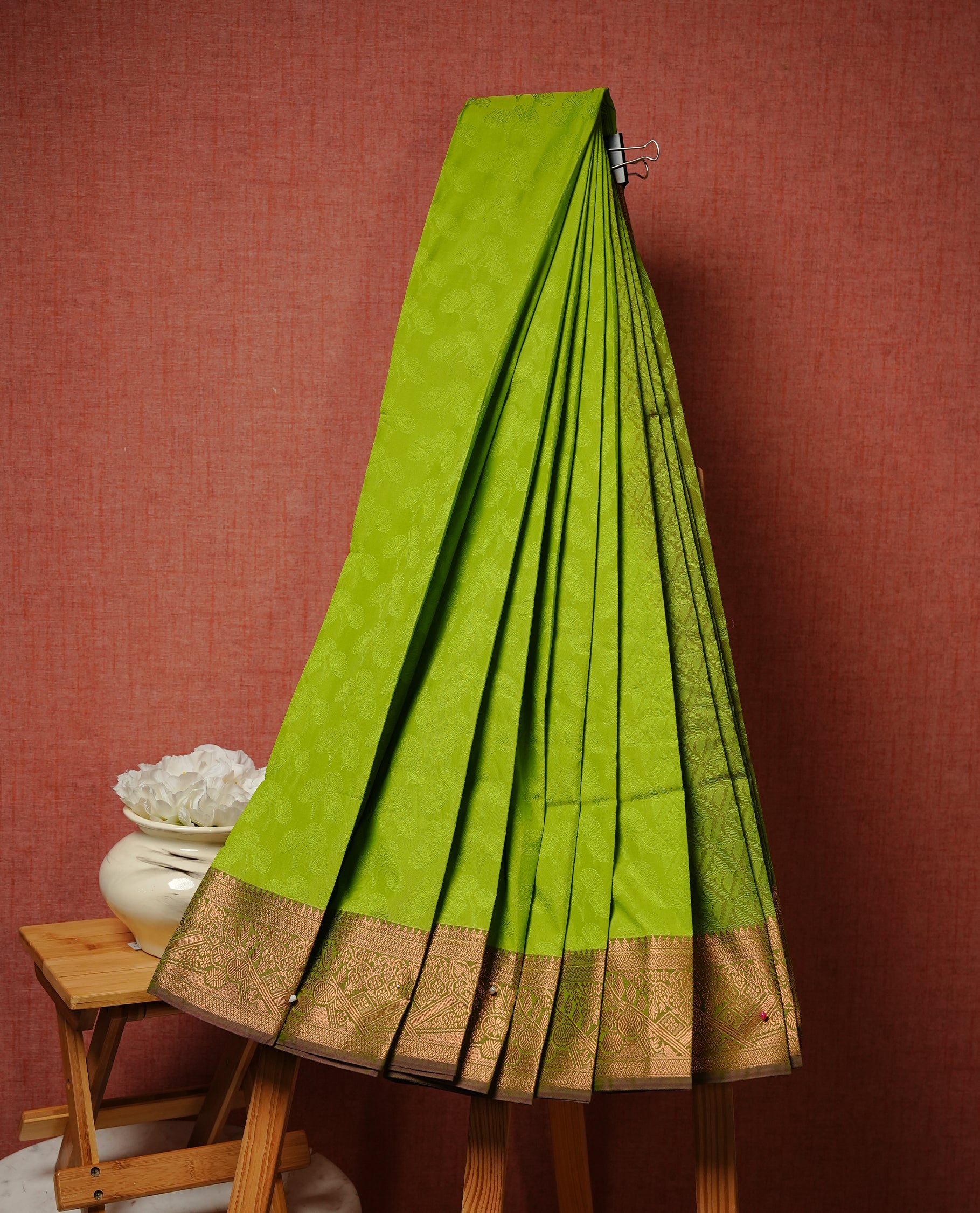 Pastel Green colour Semi silk saree Featuring selfcolour zari pattern on body, complemented by contrast Dusty purple colour with gold zari border, paired with matching blouse piece.