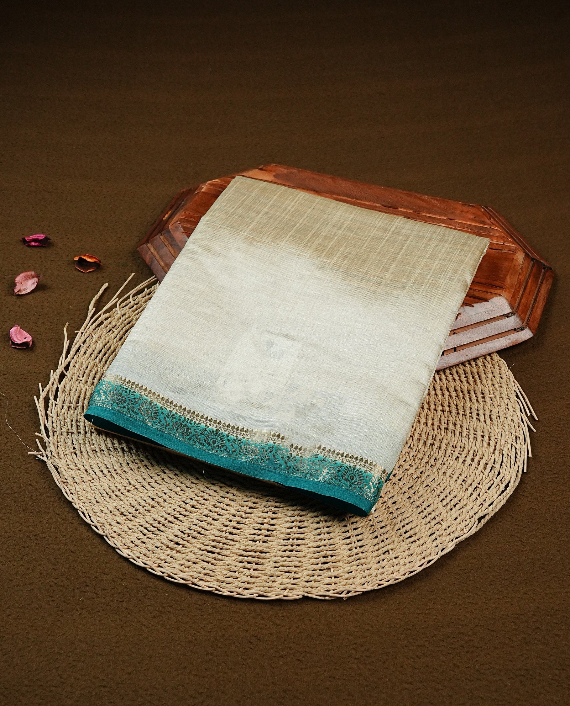 Light gold Colour Tussar saree featuring elegant plain body, complemented by contrast Teal colour with zari work border, comes with matching blouse piece.