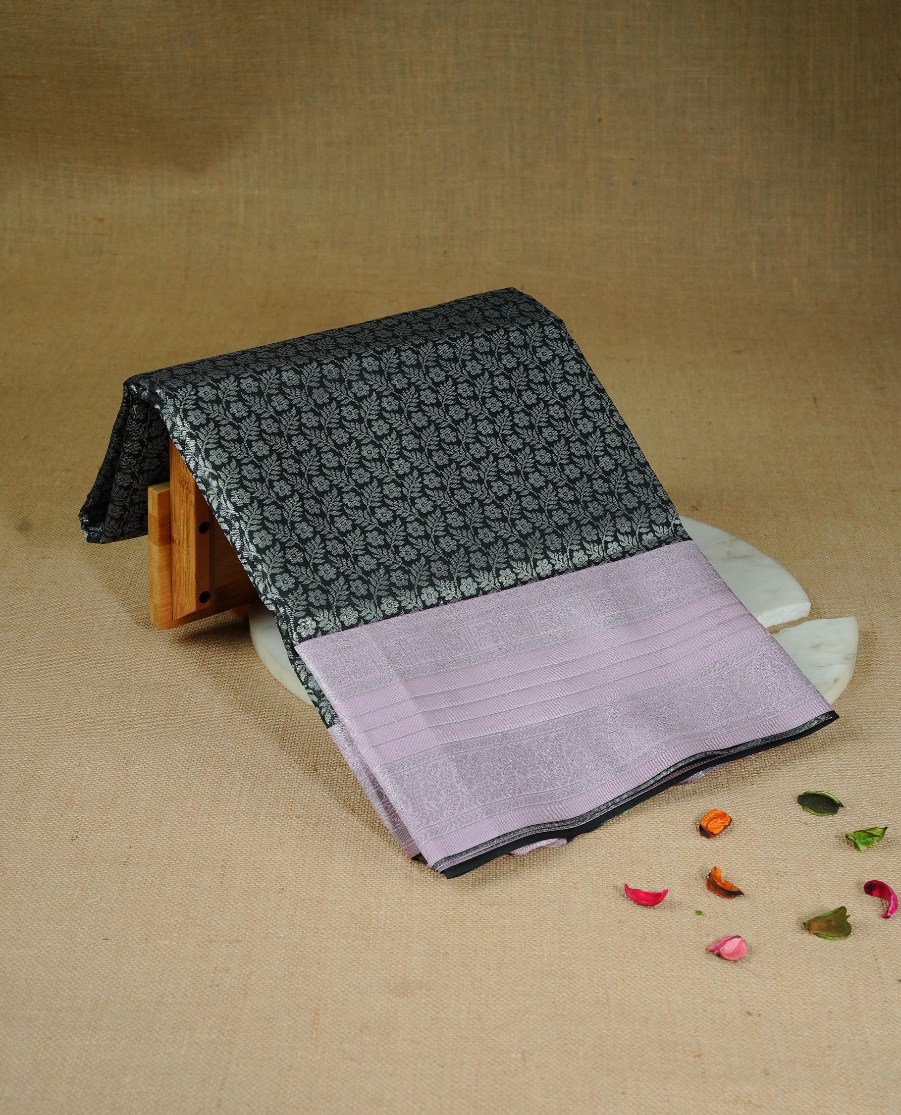 Black colour semi silk saree featuring Silver zari Floral pattern on body, complemented by contrast Pink colour with silver zari border, comes with matching blouse piece.