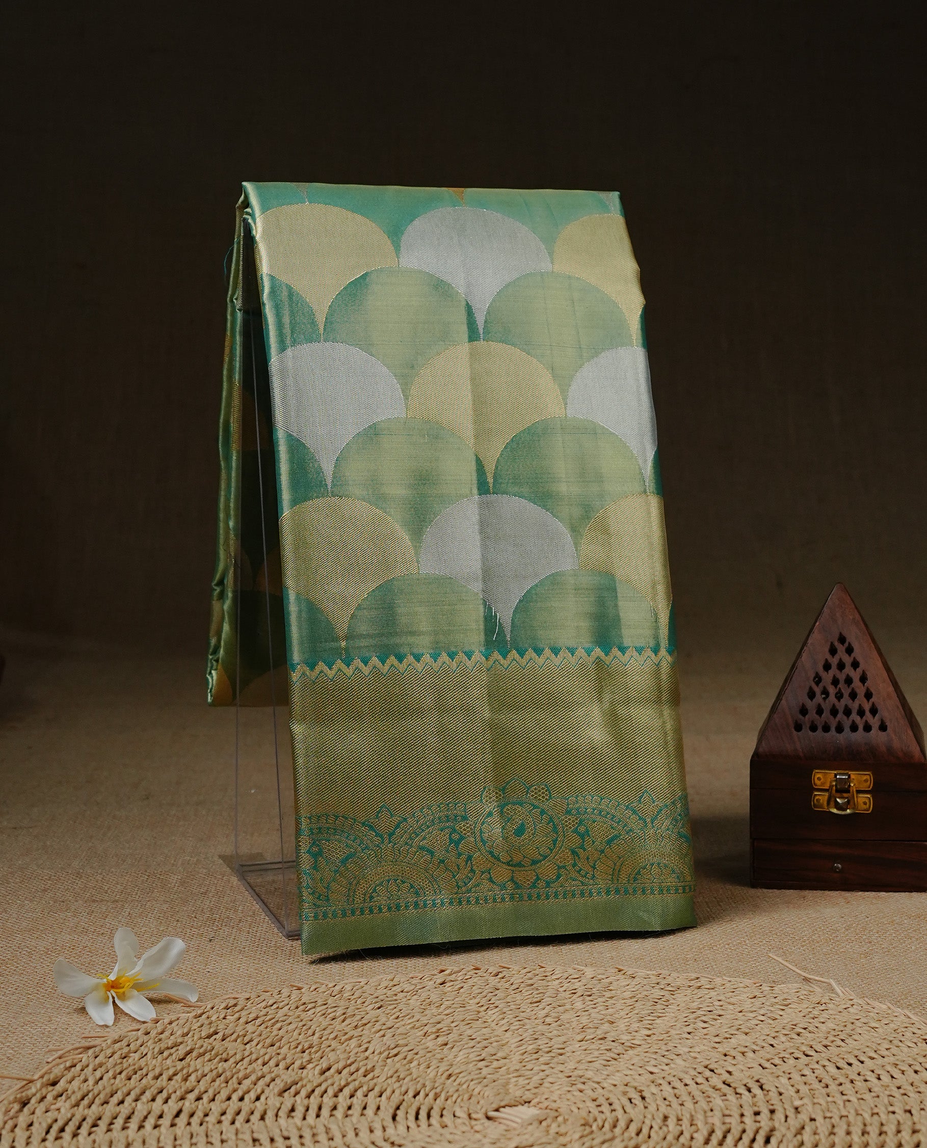 Light Green colour Tissue saree featuirng Green, Gold, silver zari Scales design on body, complemented by traditional border on self colour, paired with matching blouse piece.