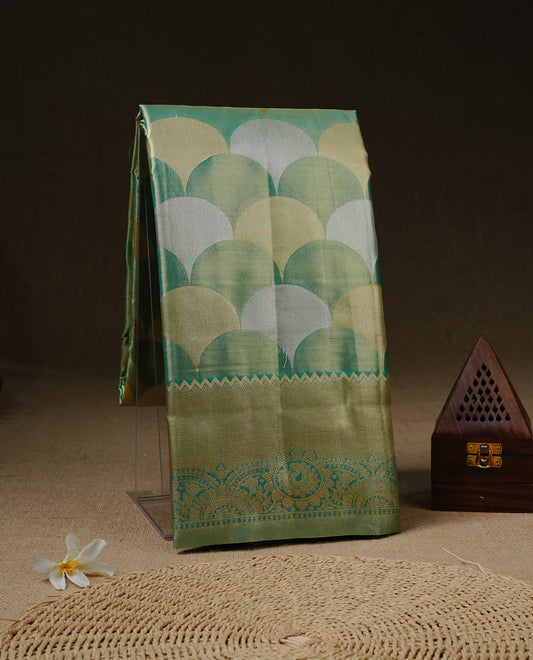 Light Green colour Tissue saree featuirng Green, Gold, silver zari Scales design on body, complemented by traditional border on self colour, paired with matching blouse piece.