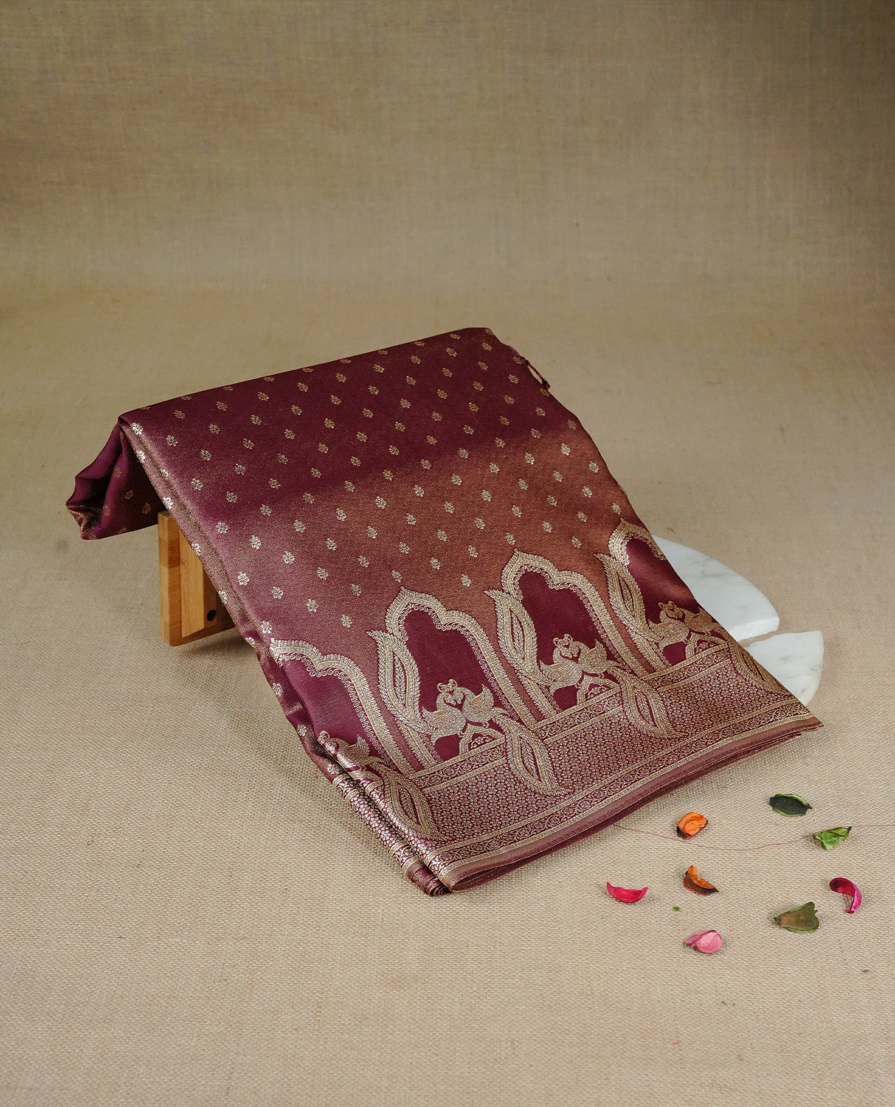 Maroon colour Mulberry silk saree featuring Gold zari buttas on body, complmented by self colour with Gold zari dual peacock in Temple design border, comes with matching blouse piece.