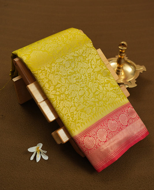 Lemon colour semi silk brocade saree featuring intricate Gold Floral kodi patterns across the body, complemented by a contrast rich red colour woven border and pallu, paired with a matching blouse.