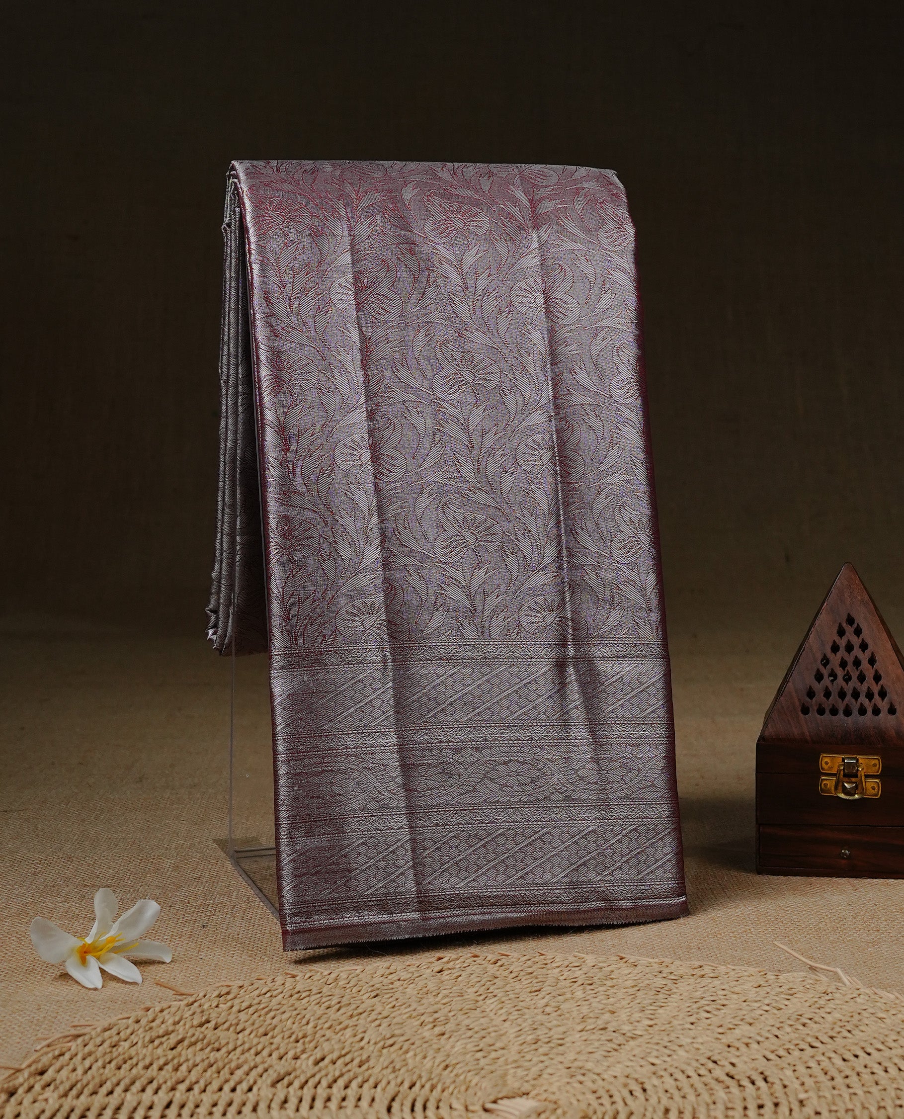 Silver & Maroon colour Tissue silk saree featuring Maroon & Silver zari kodi pattern on body, enhanced with Zari border on self colour, paired with matching Blouse piece.