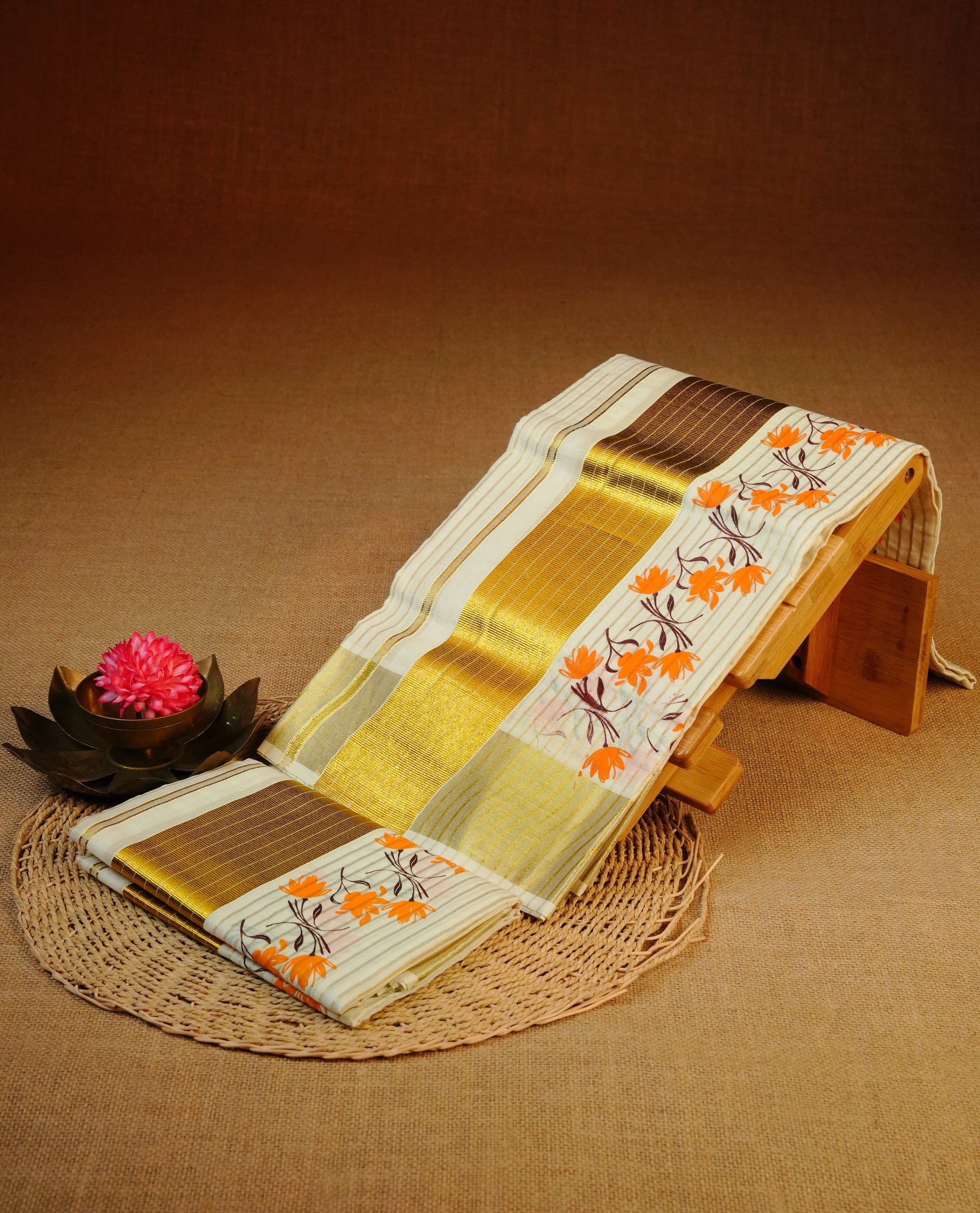 Cream colour cotton set mundu featuring Gold zari strip on body, kasav with orange floral printed kara.