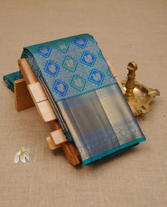 Peacock colour pure wedding silk saree featuring Gold zari inside box diamond with peacock motifs pattern on body, complemented by self colour with traditional border, comes with matching blouse piece.