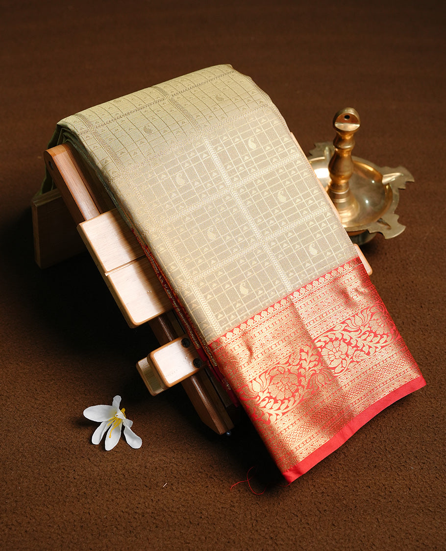 Light gold colour semi wedding saree featuring gold zari check with motifs on body, contrast red colour with traditional border, paired with matching blouse piece.