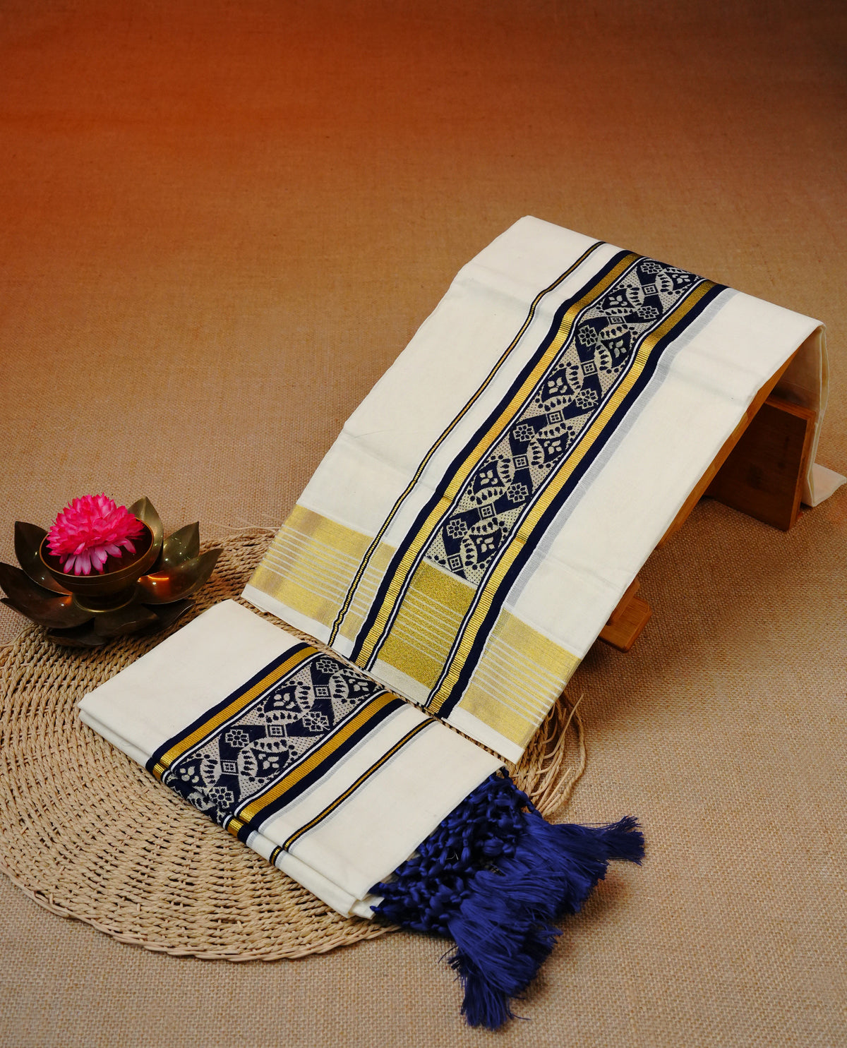 Cream colour cotton set mundu featuring Gold zari & navy blue border with Design pattern.