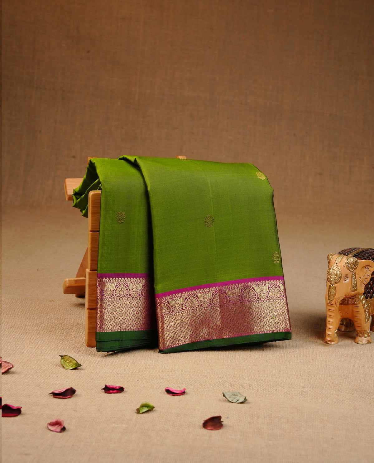 Olive Green Traditional kancheepuram silk saree featuring gold zari buttas on body, complemented by contrast Magenta & green with traditional border, comes with matching blouse piece.