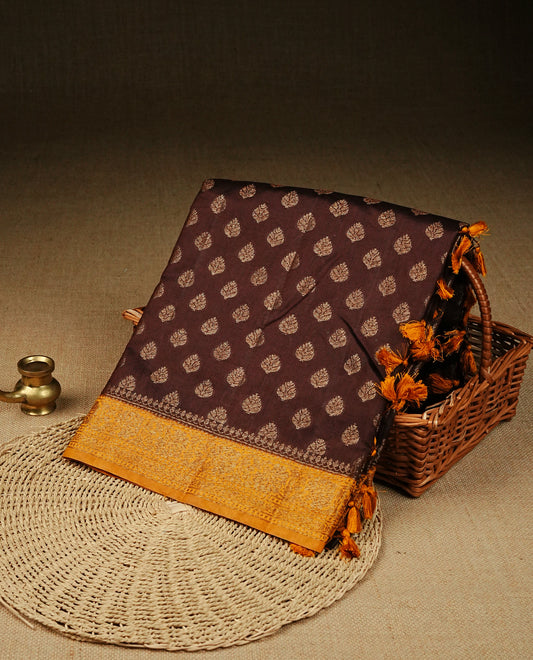 Chocolate colour banaras saree featuring Gold zari buttas on body, complemented by contrast mustard colour with simple zari border, comes with matching blouse piece.