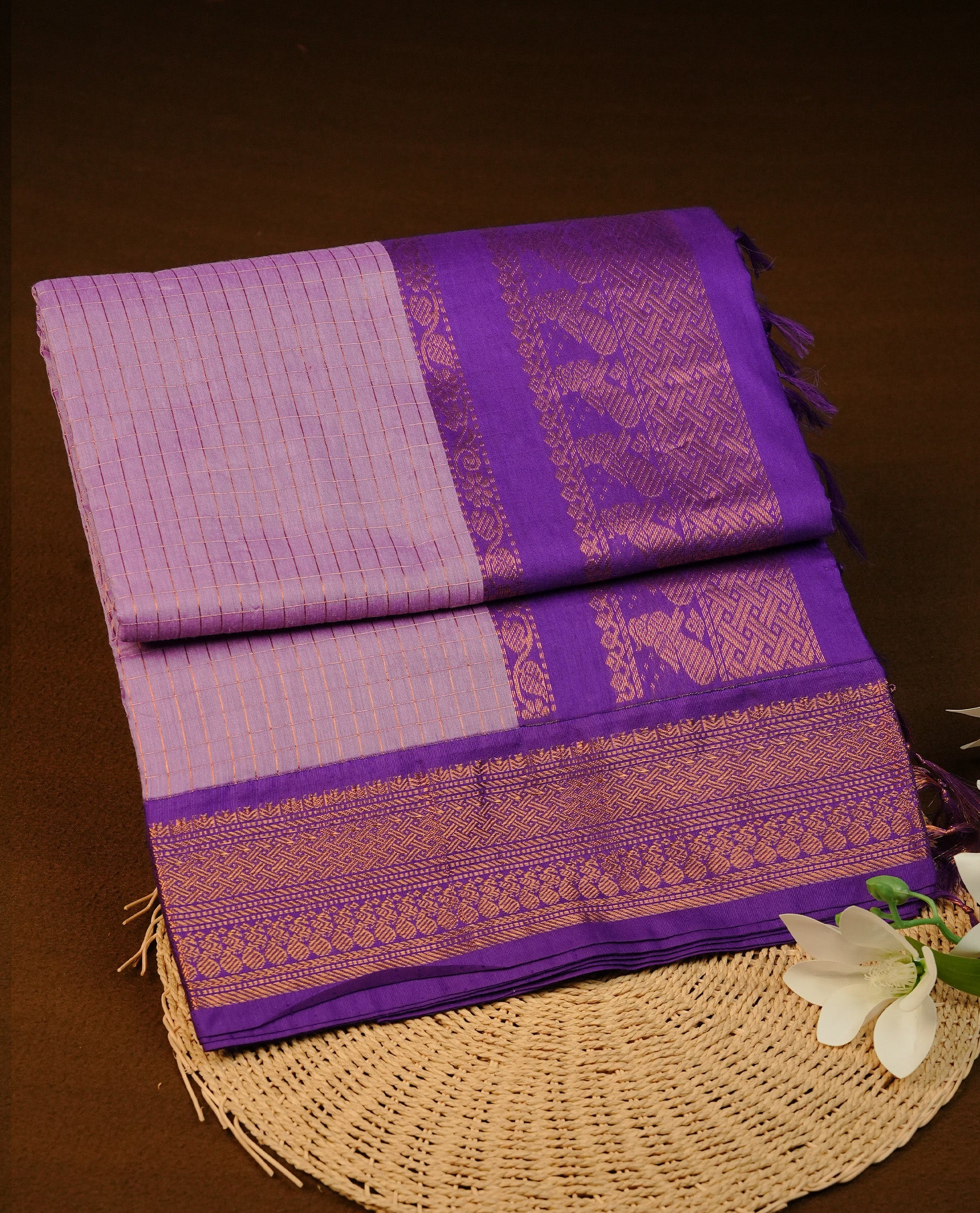 Lavender colour Kalyani cotton saree featuring Gold zari check pattern on body, complemented by Contrast Violet colour with grand gold zari border & pallu, matching blouse piece
