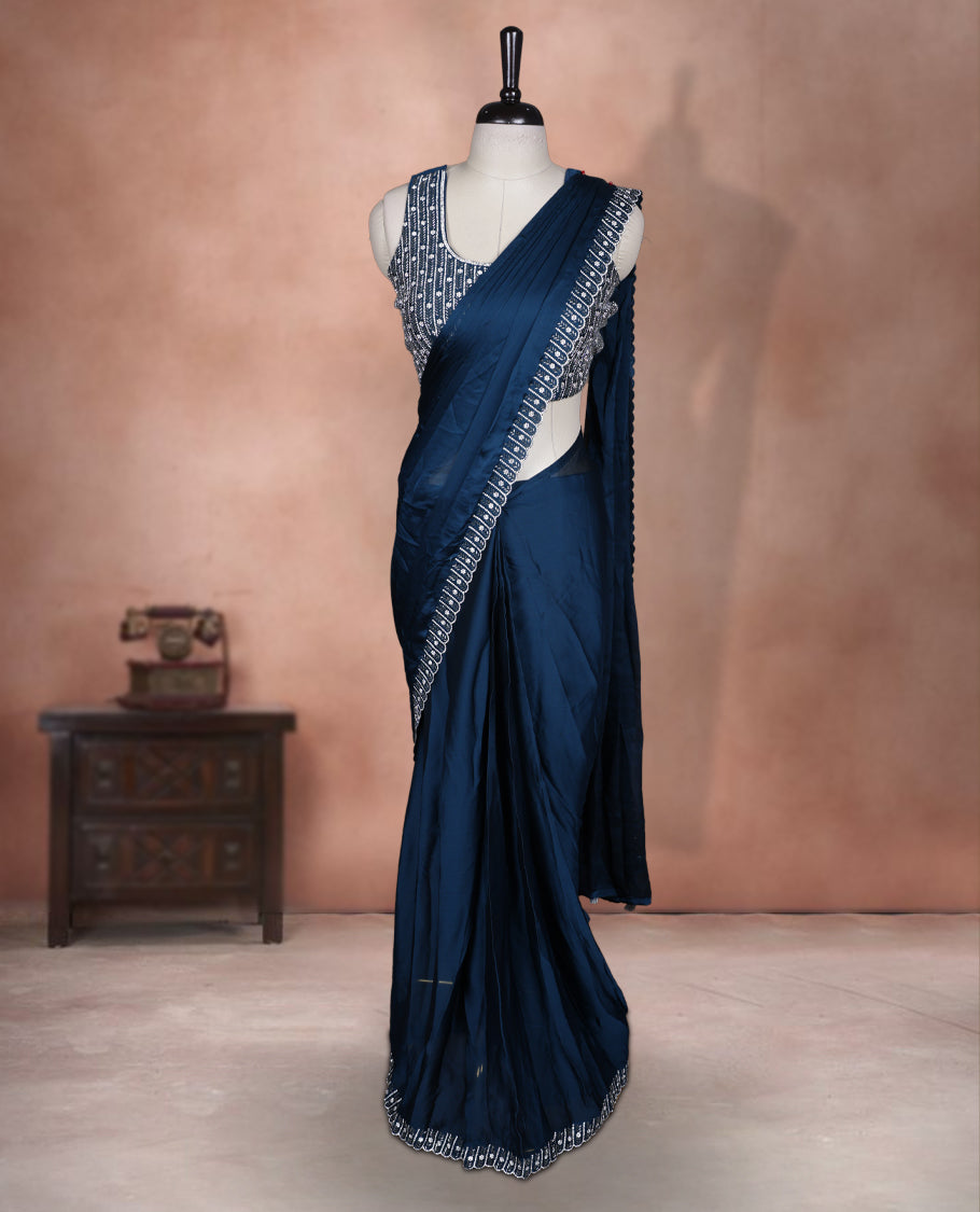 Elegant Teal colour ready to wear saree adorned with rich silver Stone and bead embroidery along the border and pallu, paired with a heavily embellished matching blouse for a grand festive look.