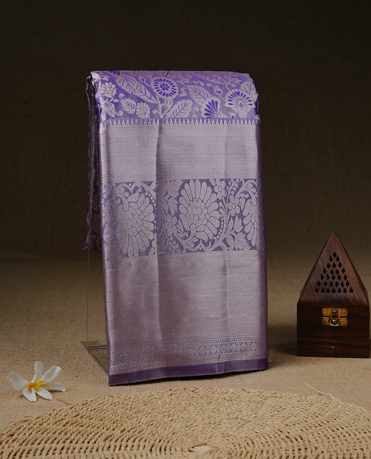 Light purple colour tissue saree featuring rose gold zari floral kodi pattern on the body, highlighted by a self colour border with rose gold traditional zari, paired with a matching blouse piece.