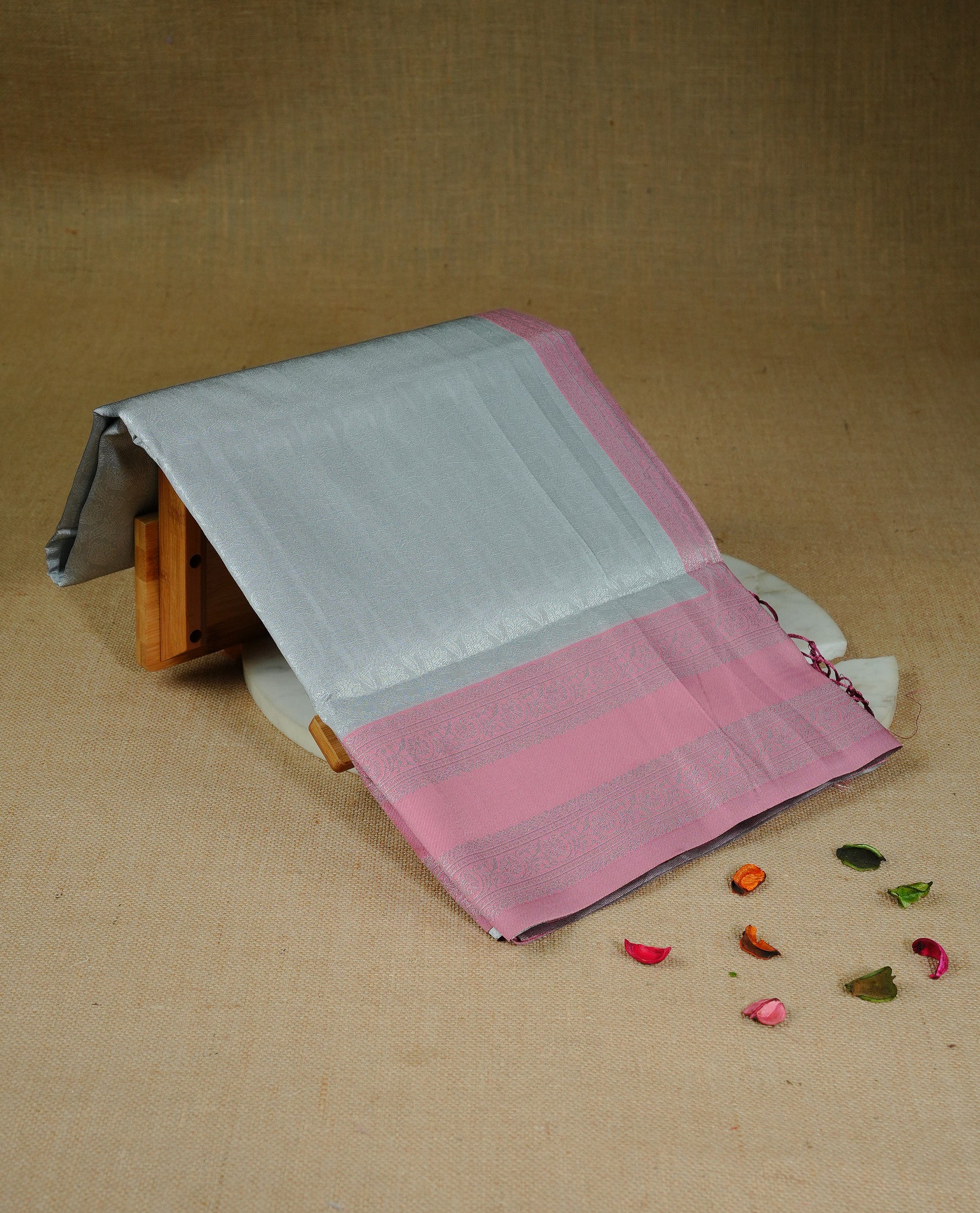 Grey colour semi silk saree featuring Silver zari Floral pattern on body, complemented by contrast Pink colour with silver zari border, comes with matching blouse piece.