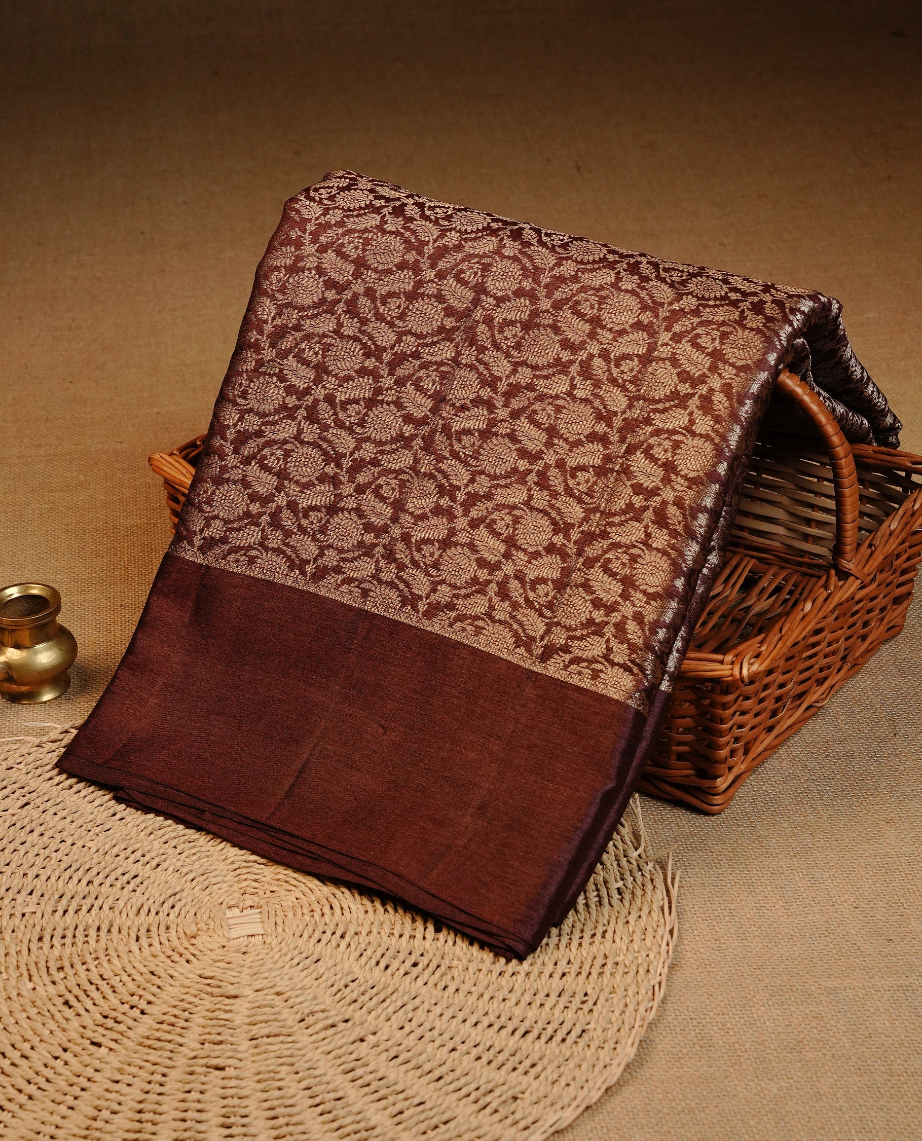 Chocolate Brown colour pure tussar silk saree featuring light gold zari floral kodi work on the body, a plain border, grand pallu,Paired With  a matching blouse piece.