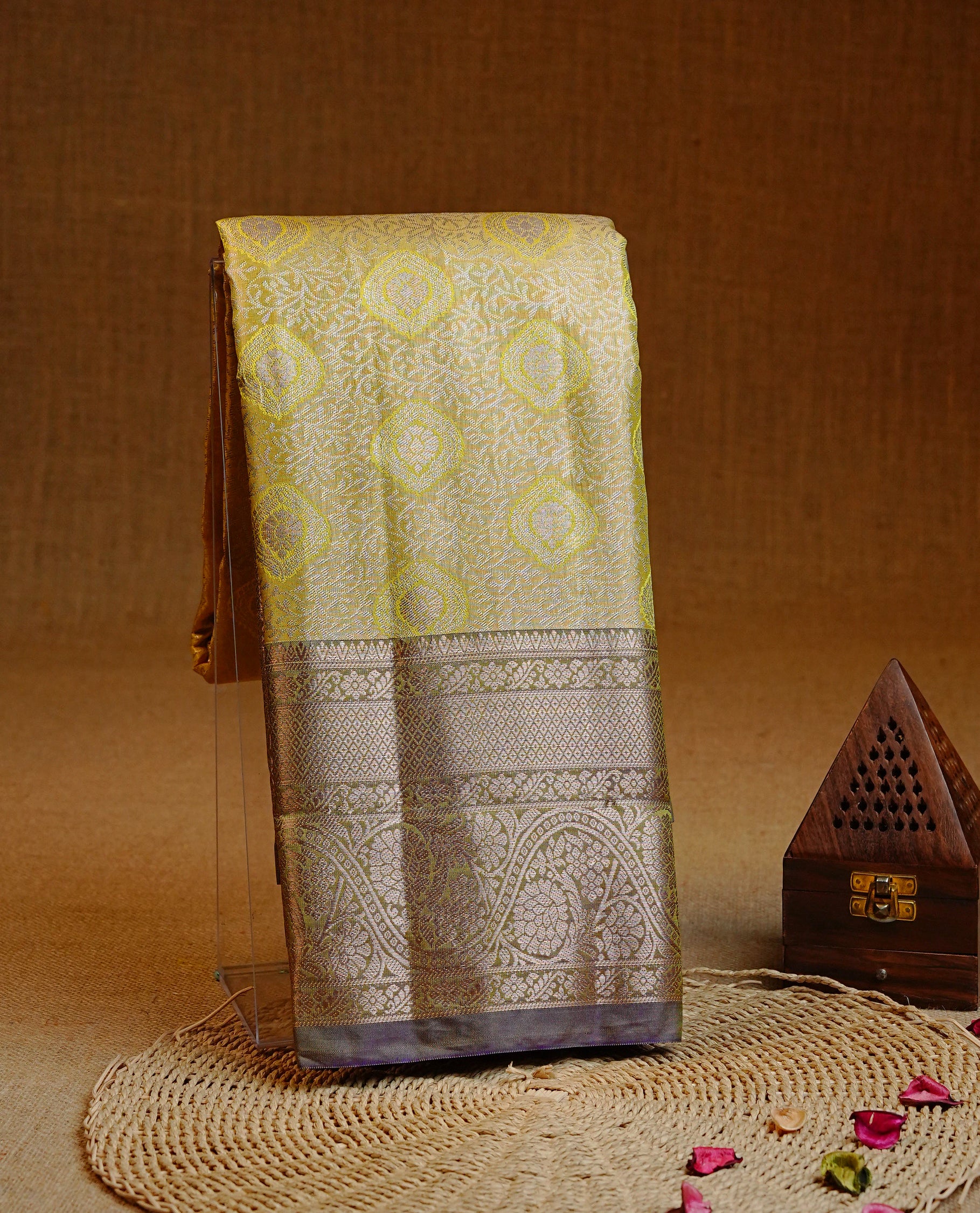 Pale yellow colour Semi tissue silk saree featuring light gold zari kodi floral motifs on body, Contrast Olive colour with traditional border, paired with matching blouse piece.
