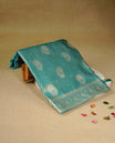 Teal colour Mulberry silk saree featuring Gold zari small buttas & floral motifs  on body, complemented by self colour with Gold zari border, comes with matching blouse piece.