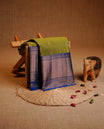 Olive Green Colour Traditional Kancheepuram Slik Saree Featuring Gold Zari Motifs on the Body, Complemented by a Contrast Blue Colour Copper Zari Traditional Border and Pallu, Paired with a Matching Blouse .