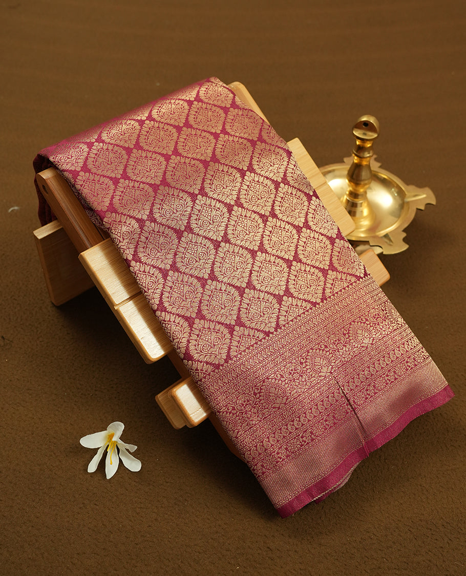 Deep brown colour semi silk brocade saree featuring intricate Gold butta patterns across the body, complemented by a rich self colour woven border and pallu, paired with a matching blouse.