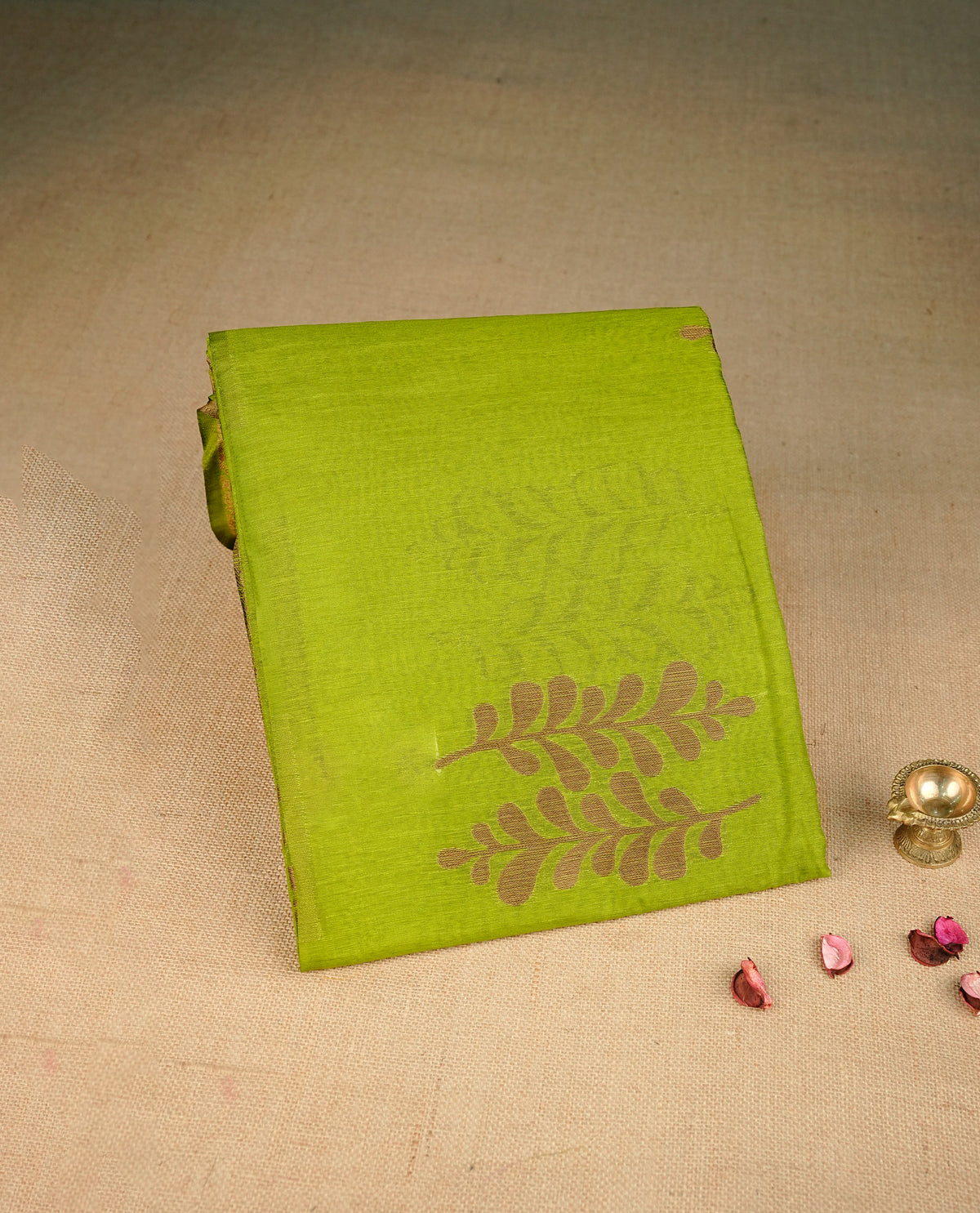 Green colour semi linen saree with elegant gold zari leaf motifs across the body, complemented by a contrast  wine colour with grand gold zari pallu and a borderless design, paired with a matching blouse piece.