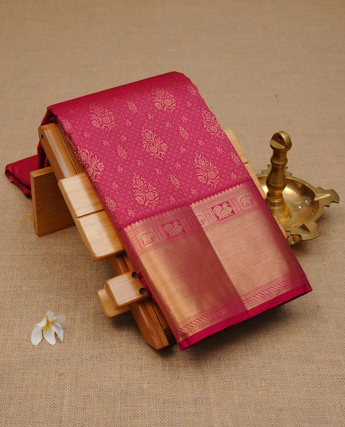 Maroon colour pure wedding silk saree featuring gold zari Small diamond & Motifs on body, complemented by self colour with traditional border, comes with matching blouse piece.