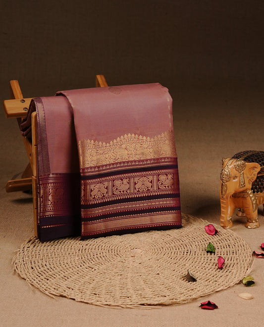 Mauve colour Traditional Kancheepuram silk saree featuring gold zari motifs on body, enhanced with contrast Purple with traditional border, paired with matching blouse piece.