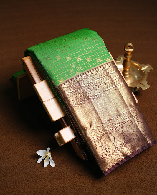 Bottle green colour semi wedding saree featuring gold zari check with motifs on body, contrast chocolate colour with traditional border, paired with matching blouse piece.