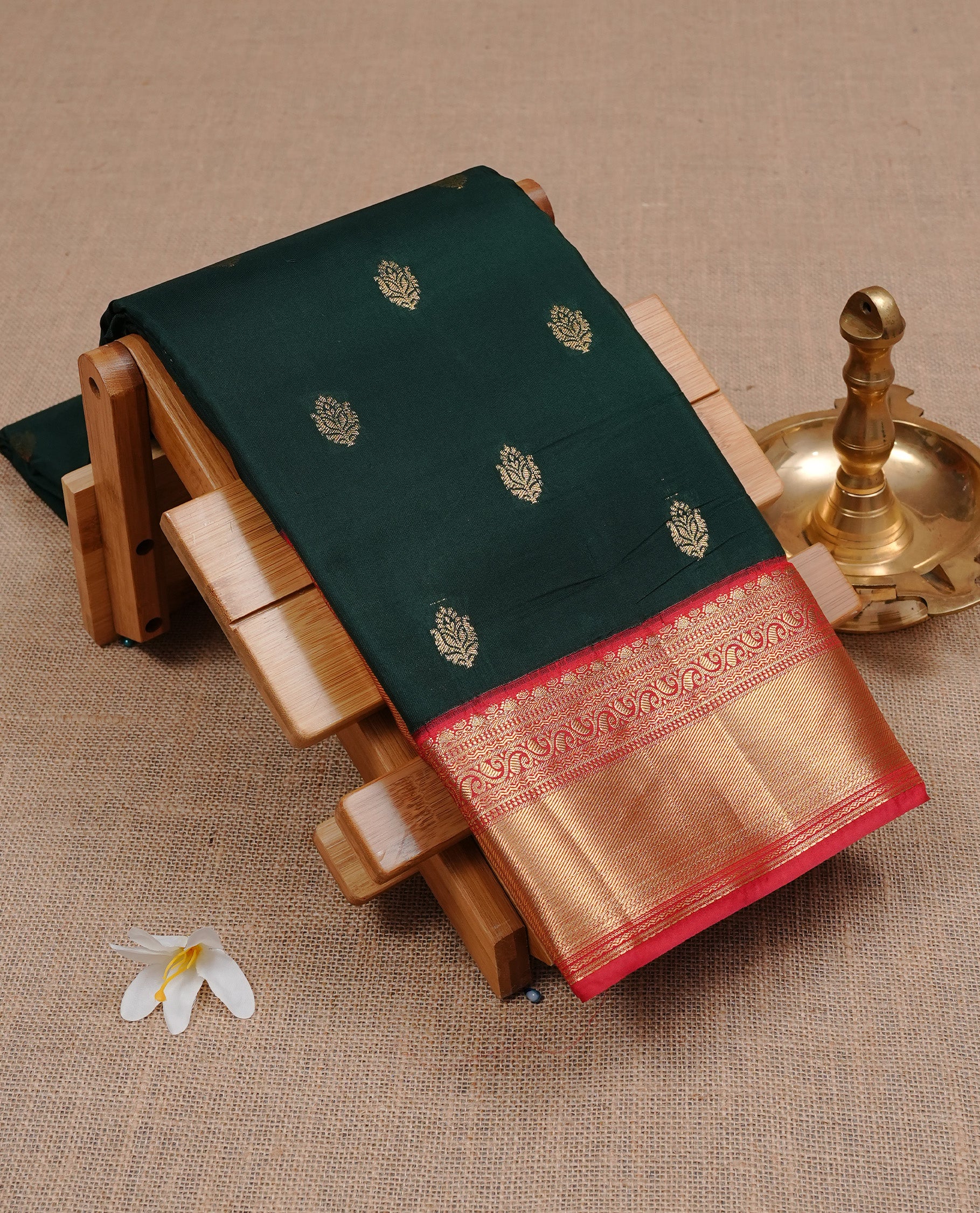 Dark Green colour semi Wedding silk saree featuring Gold zari motifs on body, enhanced with Contrast Red colour with traditional border, paired with matching blouse piece.