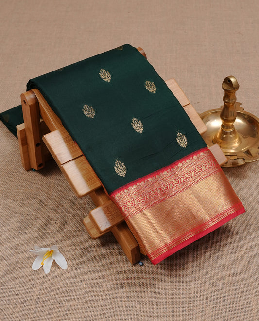 Dark Green colour semi Wedding silk saree featuring Gold zari motifs on body, enhanced with Contrast Red colour with traditional border, paired with matching blouse piece.