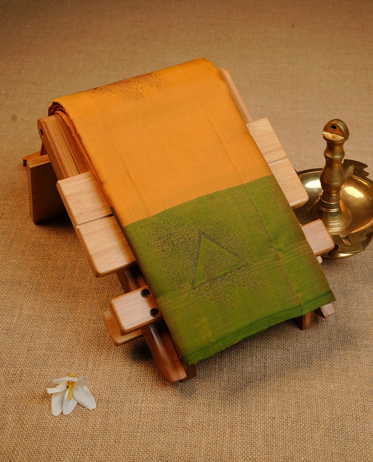 Mustard Colour Traditional Kancheepuram Silk Saree Featuring Bronze Zari Triangle Motifs on the Body, Designed With a Green Border and with a Grand Pallu, Paired with a Matching Blouse.