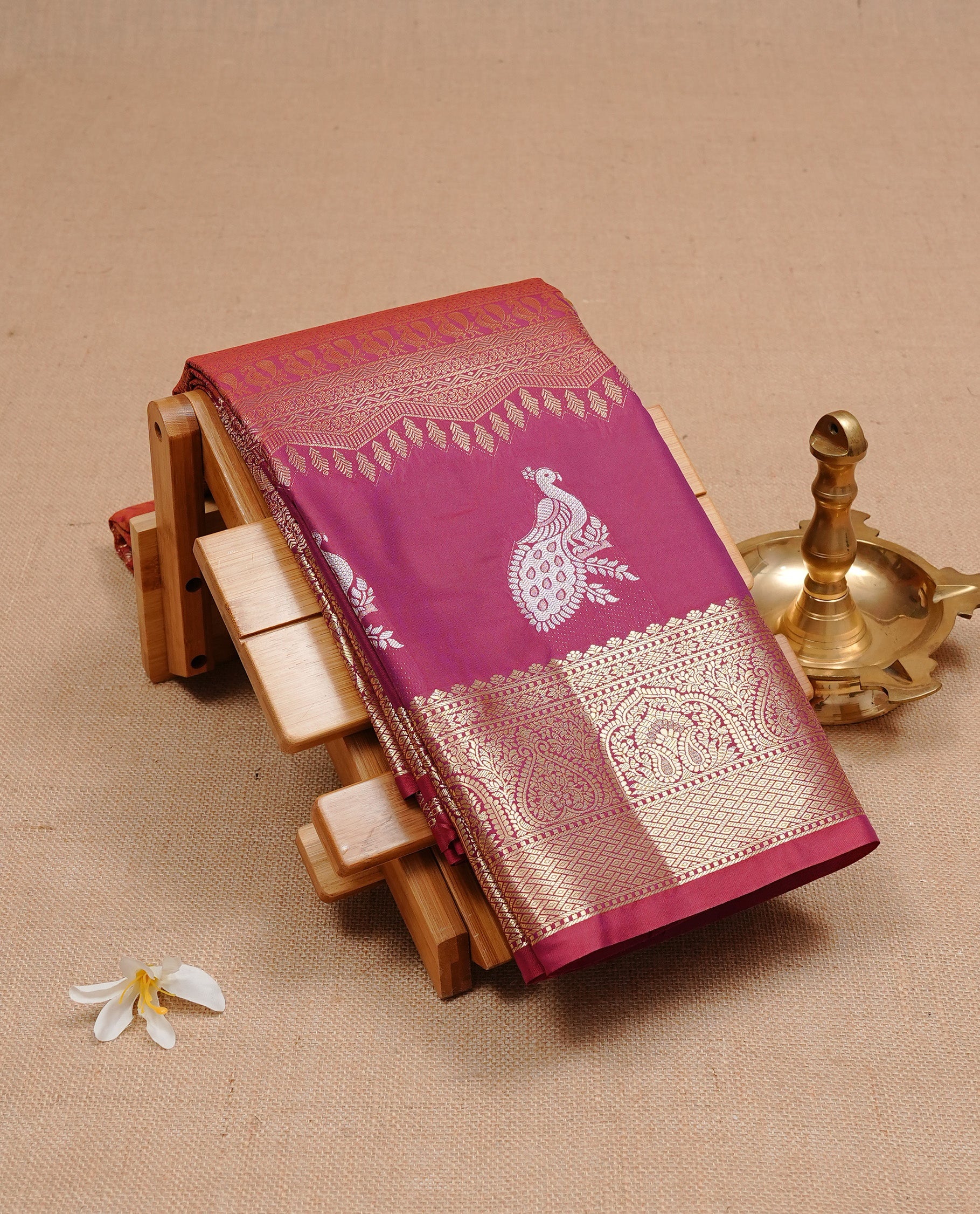 Burgundy colour semi wedding silk saree featuring Gold zari pattern on body, complemented Silver Peacock motifs & gold zari border, paired with matching blouse piece.