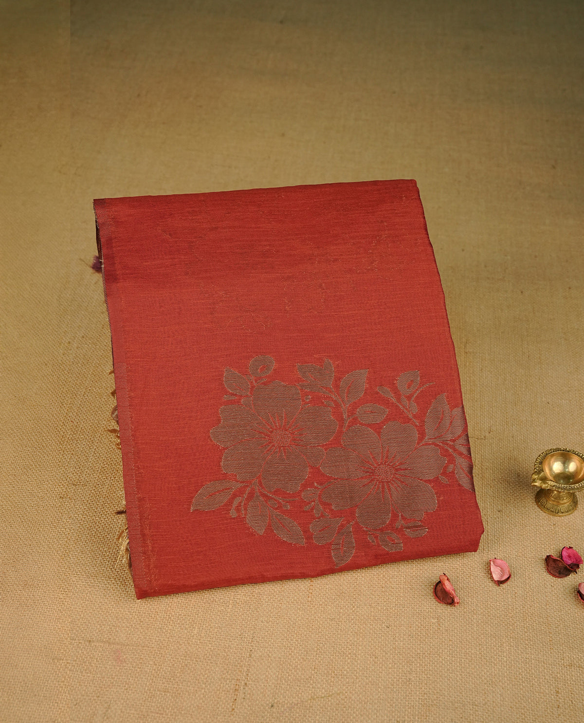 Brick red colour semi linen saree with elegant gold zari floral motifs across the body, complemented by a contrast colour with grand gold zari pallu and a borderless design, paired with a matching blouse piece.