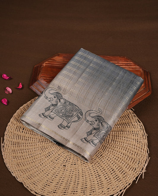 Gray colour semi tusser silk saree featuring Gold zari check pattern across body, faded contrast cream colour border with elephant print and paired with matching blouse.
