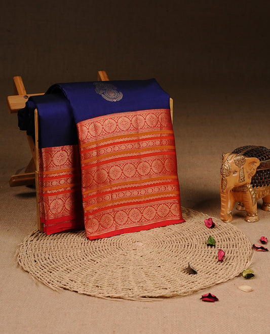 Navy Blue colour Traditional Kancheepuram silk saree featuring gold zari motifs on body, enhanced with contrast Red with traditional border, paired with matching blouse piece.