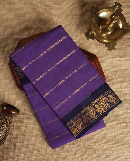 Purple colour Chettinad cotton saree adorned with subtle golden zari stripes all over, The contrast black border features intricate peacock and floral motifs & Comes with a matching blouse piece.