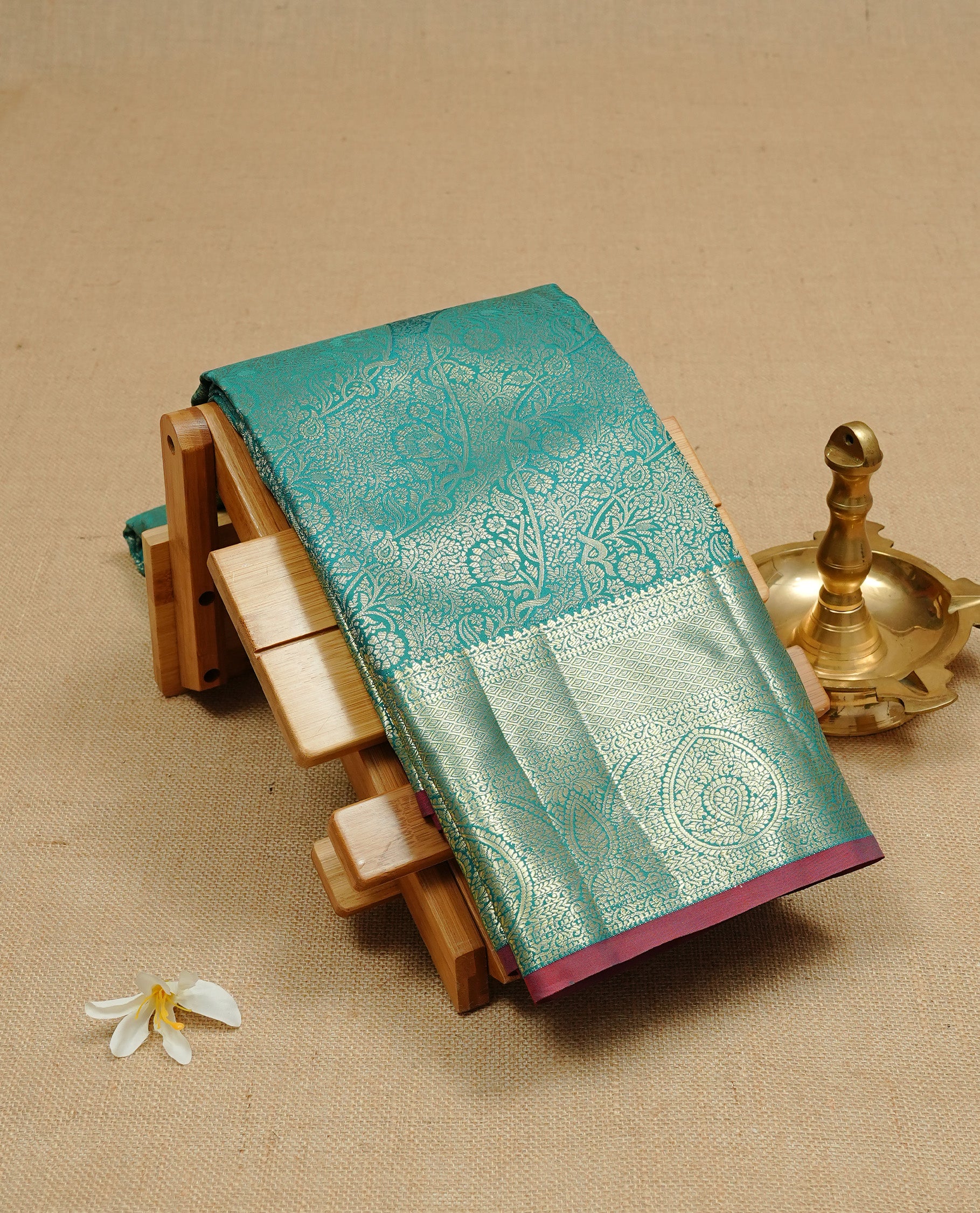 Green colour semi wedding silk saree featuring Gold zari floral kodi pattern on body, complemented by Traditional zari on self colour with Maroon piping, paired with matching blouse piece.
