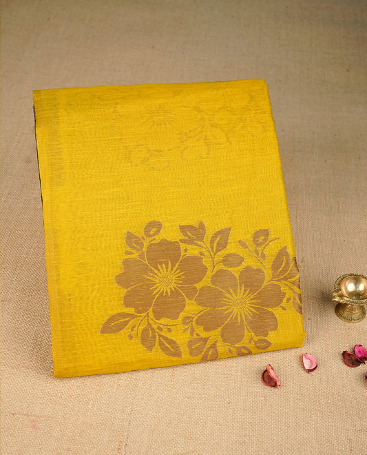 Mustard yellow colour semi linen saree with elegant gold zari floral motifs across the body, complemented by a contrast forest Green colour with grand gold zari pallu and a borderless design, paired with a matching blouse piece.