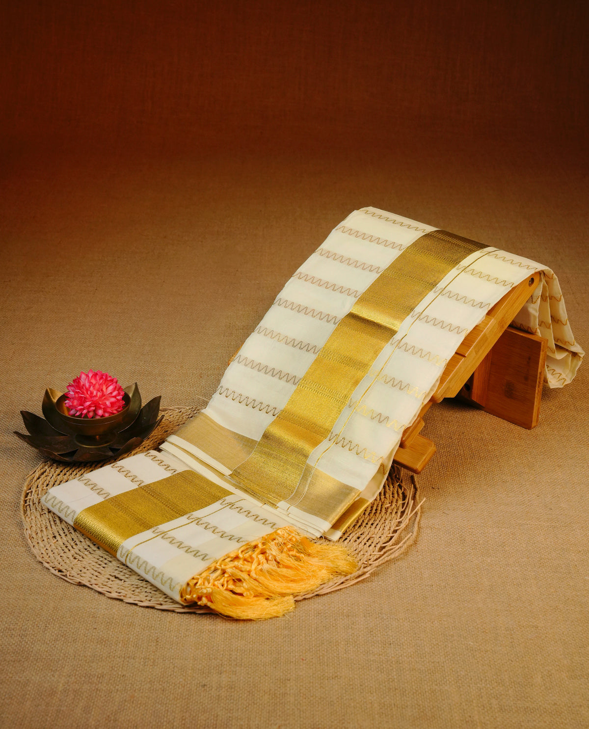 Cream colour cotton set mundu featuring gold zari zigzag strips on body, gold kasav kara.