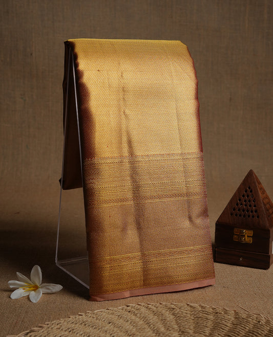 Gold colour kancheepuram tissue silk saree highlighting gold stripped zari pattern body, with contrast Pinkish beige colour colour with traditional border and paired with matching blouse.