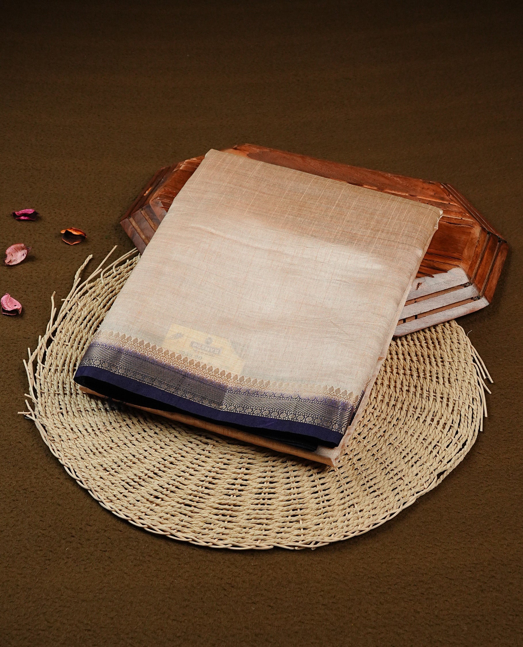 Light gold Colour Tussar saree featuring elegant plain body, complemented by contrast Navyblue colour with zari work border, comes with matching blouse piece.