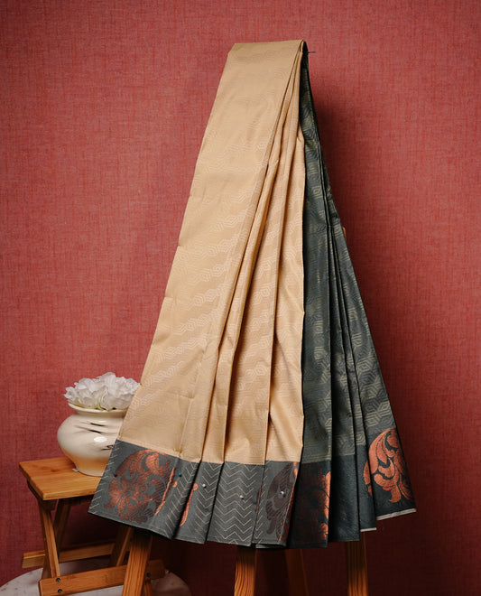 Light khaki colour Semi silk saree Featuring self colour zari Pattern on body, complemented by contrast Green colour with Antique zari border, paired with matching blouse piece.