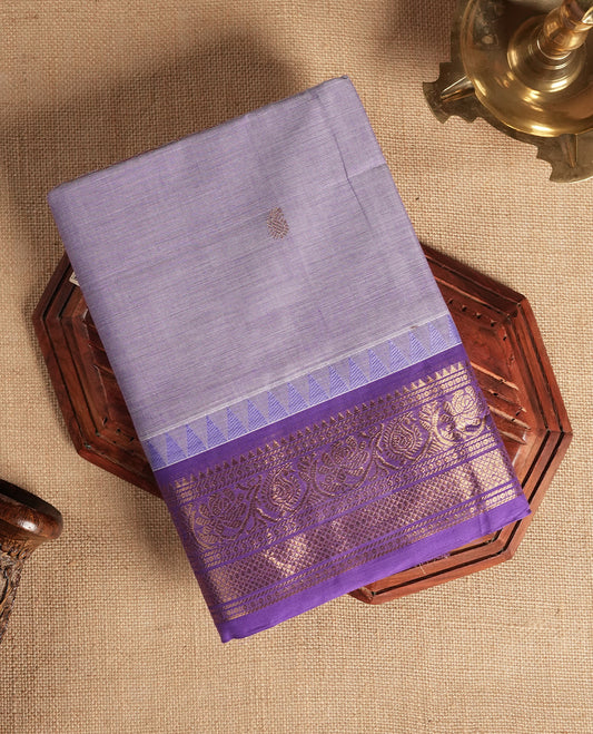 Lavender colour Chettinad cotton saree featuring subtle small motifs on the body, The saree is highlighted with a rich purple zari woven border adorned with floral and geometric patterns & Comes with a matching blouse piece.