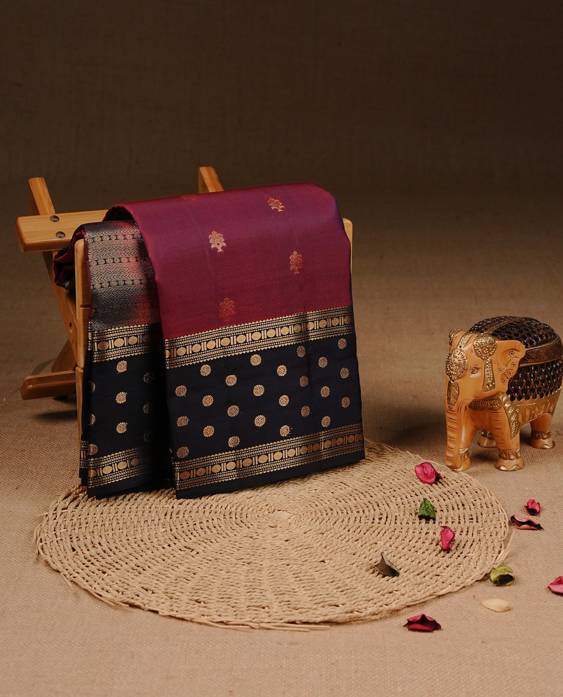 Burgundy colour Traditional Kancheepuram silk saree featuring gold zari motifs on body, enhanced with contrast Dark Blue with traditional border, paired with matching blouse piece.