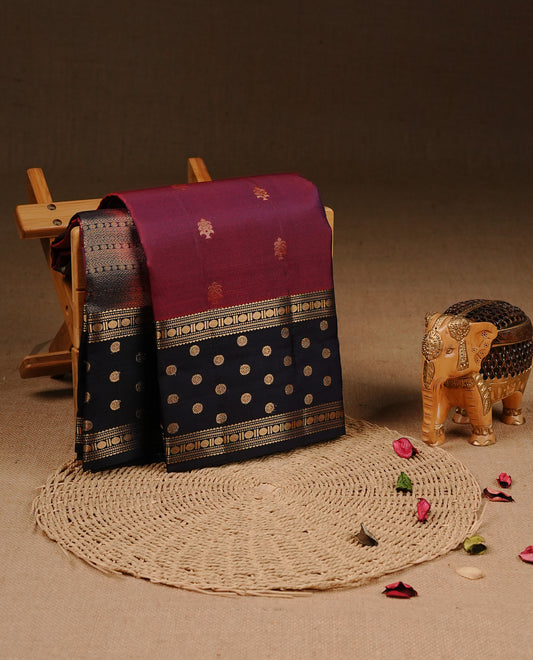 Burgundy colour Traditional Kancheepuram silk saree featuring gold zari motifs on body, enhanced with contrast Dark Blue with traditional border, paired with matching blouse piece.