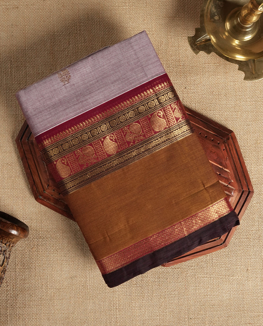Pastel purple colour Chettinad cotton saree featuring small motifs on the body, highlighted with a rich brown and maroon zari woven border and intricate pallu design & Comes with a matching blouse piece.