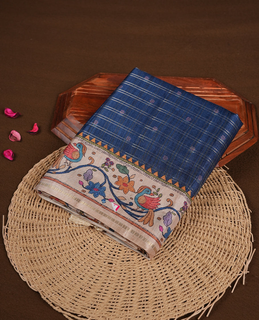 Dark blue colour semi tusser silk saree featuring gold zari check pattern with floral butti motifs, with contrast floral kodi & bird pattern and paired with matching blouse.